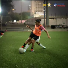 A female player executing a strong tackle during a practice match. Our girls' program emphasizes developing both technical skill and competitive toughness.