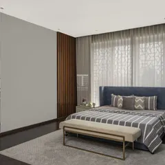 In this bedroom, we used vertical fluted paneling behind the bed to add texture and height. The custom blue bed and matching ottoman create a serene and unified color scheme, perfect for a restful space.