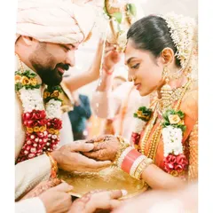 A tender moment during a traditional Indian wedding ceremony. The groom's gentle touch and the bride's serene expression are captured in this intimate and emotional photograph.