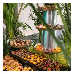 Another view of our spectacular dessert table, showcasing a three-tiered fountain of macarons and candies, surrounded by an assortment of pastries and tarts.