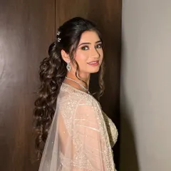 Channeling elegance with a touch of whimsy for a Sangeet night. This high, curly ponytail is perfect for dancing the night away.