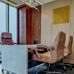 The executive cabin for Mr. Mohammad Siraj of Sun Group, featuring a minimalist marble desk set against rich wood paneling. The design balances natural light from the large window with modern, sculptural overhead lighting.