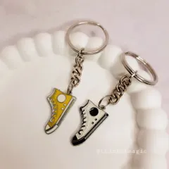 A close-up of the yellow and white shoe charm keychains. They are a fun and stylish accessory for backpacks or keys.