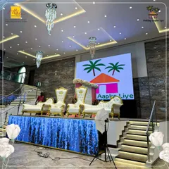 The stage at our Karjat venue is fully equipped for a grand event, featuring a large LED screen for custom backdrops and presentations. The ornate white and gold thrones provide a regal seating option for the guests of honor.