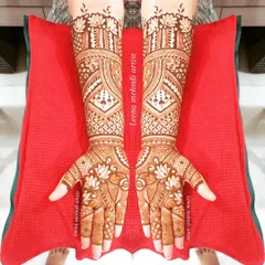 This full-coverage design for a bride is filled with lotus motifs and detailed geometric patterns. The symmetry across both hands creates a balanced and harmonious look, extending beautifully up the forearms.