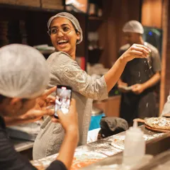 Our "Parm Queen" having fun while making pizzas, with a friend capturing the moment. It's all about enjoying the process.