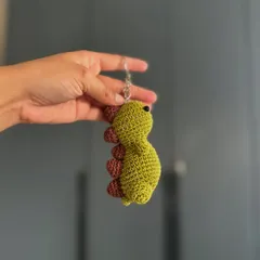 A tiny dinosaur keychain to guard your keys. This amigurumi dino is a fun and quirky accessory for all ages.