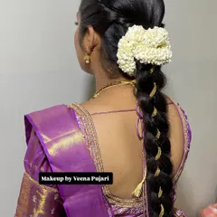 A thick, traditional braid woven with gold thread and topped with a fragrant jasmine gajra. This style is perfect for a classic Kanjeevaram saree look.
