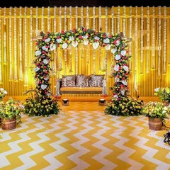 For this vibrant Teej celebration, we created a stunning stage featuring a backdrop of traditional marigold garlands. The setup was flanked by magnificent peacocks sculpted from white flowers, set against a chevron-patterned floor, blending classic Indian motifs with a modern aesthetic.