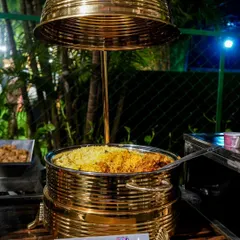 Our signature Biryani, served in a traditional brass pot. This is a cornerstone of our menu, loved for its rich flavor and fragrant aroma.