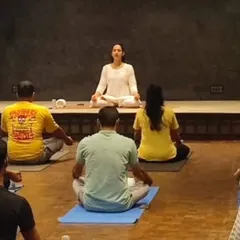 Leading a group of professionals in a seated meditation. Even a few minutes of guided mindfulness can significantly lower stress levels and increase mental clarity for the rest of the workday.