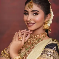 A smiling portrait showcasing the complete look. The antique gold temple jewelry adds a layer of traditional grandeur to the contemporary saree.
