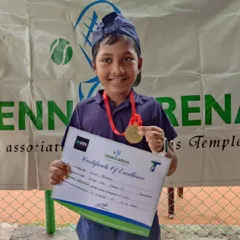 Every player is a winner here. This young athlete is all smiles with his medal and certificate after participating in our beginner's tennis tournament.