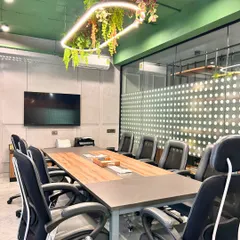 The boardroom was designed for collaboration, blending natural textures with a suspended green ceiling element. The custom light fixture with hanging plants introduces softness and a refreshing, biophilic touch.