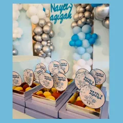 Custom gift boxes we created for an Aqeeqah ceremony. These lavender boxes were filled with sweets and featured personalized toppers with the baby's name, perfectly matching the event's blue and silver decor.