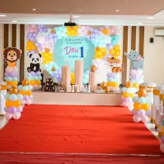A "Little Sunshine" jungle animal theme for Ditvi's first birthday, featuring a wide stage setup with animal balloon columns.
