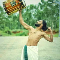 Hoisting the 13kg chenda with ease. This shows the incredible strength and dedication of our performers.