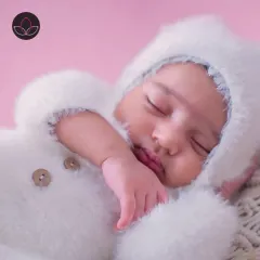 A close-up on the sweet face of the newborn in a bunny outfit, capturing the delicate features and peaceful expression.