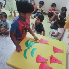 A camper works on a watermelon craft, learning about shapes and letters in a fun, summer-themed activity. Our camp blends learning with seasonal fun.