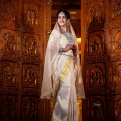 This stunning Iyer bride wanted to honor her groom's heritage by wearing a Kannadiga-style drape for one of her ceremonies. I created this elegant look for her, blending traditions beautifully against the backdrop of an intricately carved wooden doorway.