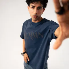An engaging shot for a streetwear brand where the model reaches towards the camera. This dynamic pose draws the viewer in and showcases the t-shirt's design in a creative, interactive way.