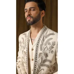A detailed view of the 'Pragyan' shrug's embroidery. This shot highlights the cream and gold threadwork, showcasing the garden-inspired motifs and the precision of the hand-stitching.