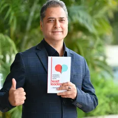 An outdoor portrait of the author giving a thumbs-up with his book. This creates a positive and successful image, great for social media announcements.