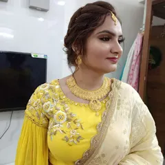 A profile view highlighting the soft, blended eyeshadow and the elegant maang tikka. Her skin looks smooth and radiant, perfect for celebrating such a special day.