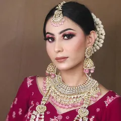 A complete bridal set featuring a beautiful choker, matching jhumkas, and maang tikka with delicate pink bead drops. This set is perfect for pairing with pastel or pink-toned lehengas.