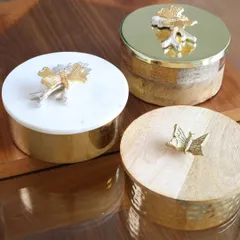 A trio of our exquisite keepsake boxes, showcasing the different designs available. From marble and wood to hammered metal, each box is a unique piece designed to hold your most precious items.