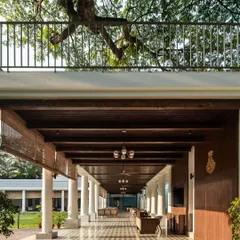 For the historic Bangalore Club, I designed this L-shaped colonnade to enhance the main lawn without overpowering the 100-year-old heritage buildings. The design provides elegant, sheltered seating while preserving the site's character, using traditional tiles and local Sadharhalli stone.