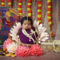 Another beautiful newborn styled for Navratri. Wrapped in purple and nestled among flowers and festive decor, she looks like a tiny sleeping goddess.