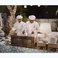 My chefs working at a beautifully arranged live station. Their professionalism and crisp uniforms are a key part of the premium experience I deliver.