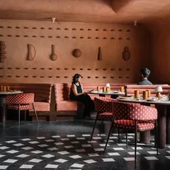 The dining area at Idylll, where earthy lime-plastered walls are adorned with custom terracotta artifacts. The space is inspired by Jaipur's timeless traditions, creating a narrative that complements the culinary experience.