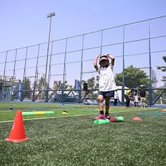 A Pre-K student balances on a beam during an obstacle course at our Annual Sports Meet.