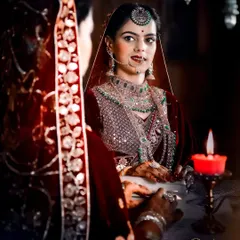 I love playing with light and shadow to create dramatic and artistic bridal portraits. This shot of the bride looking into the mirror, lit by a single candle, captures a moment of quiet reflection before the ceremonies begin.