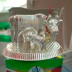 German silver se bani yeh Cow and Calf ki murti return gifts ke liye bahut lokpriya hai. Yeh silver finish mein hai aur iske saath ek ghanti bhi hai.