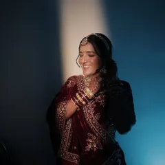 An artistic portrait of the Marwadi bride. The lighting highlights the flawless base and soft contouring, while her hair is styled in an elegant braided updo.
