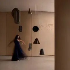 A motion-blurred figure interacts with hanging sculptural elements in the showroom, emphasizing the space's focus on movement and sensory experience.