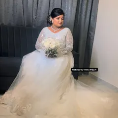 A full-length view of this gorgeous bride in her wedding gown. The makeup is designed to look timeless and elegant, ensuring she looks perfect in all her wedding photos.