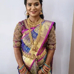 This client is ready for her reception. This phone photo shows a classic look with a beautiful multi-toned silk saree, traditional gold jewelry, and a hairstyle of soft curls.