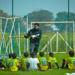 A coach gives a halftime talk to his young team, providing guidance and motivation for the second half.