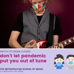 A student wearing a mask plays an electric guitar, illustrating our commitment to safe in-person learning. Our hybrid model allows for seamless continuation of lessons online when needed.