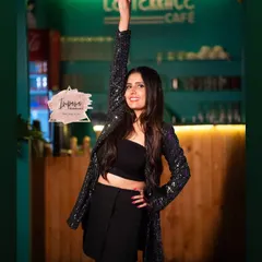 A fun and chic look for a portfolio shoot at a cafe. The model is wearing a sequined jacket, and her makeup is modern and glamorous.