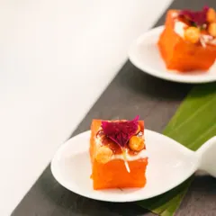 A closer look at our dhokla, presented as a delicate bite-sized cube on a spoon. It's a small taste of our philosophy: familiar flavours, presented in an entirely new light.