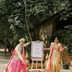 A fun and happy welcome! A couple playfully gestures towards their wedding sign, inviting guests to join in their celebration.