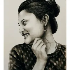 A candid-style charcoal portrait of a smiling woman. The detailed shading on her face and hair bun showcases the realism of my sketch work.