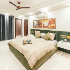 This bedroom combines a rich, green velvet-fluted headboard with warm, colorful artwork. The floating white nightstands and soft bedding complete this look of modern luxury.