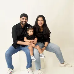 A simple and sweet family portrait. The parents and their daughter are dressed in casual black shirts and jeans, creating a relaxed and relatable family photo.