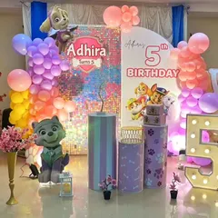 This Paw Patrol party for a 5th birthday combines a shimmering sequin backdrop with character cutouts of Skye and Everest. The pastel and rainbow color scheme gives it a unique, vibrant look.